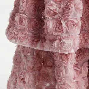 Primo piano dettagliato del pizzo rosa con rose 3D di un elegante abito stile francese
