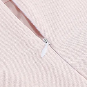 Detalle de primer plano de una cremallera invisible blanca en tela de vestido rosa claro