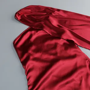 Primer plano del lujoso tejido de satén rojo vino de este elegante vestido de diseño