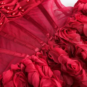Primer plano de vestido de fiesta rojo con corsé de cuentas y falda con flores 3D