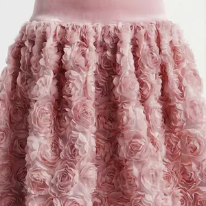 Dettaglio dei pizzi a rose 3D in tessuto rosa su un abito in stile francese