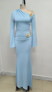 Detalle del conjunto de vestido largo azul claro con un hombro y flores de oro