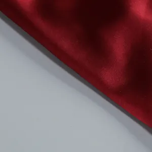 Primer plano de elegante tela de satén burdeos con textura fina y brillo de seda