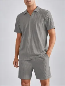 Dettaglio di un completo polo e pantaloncini grigi a pieghe da uomo.