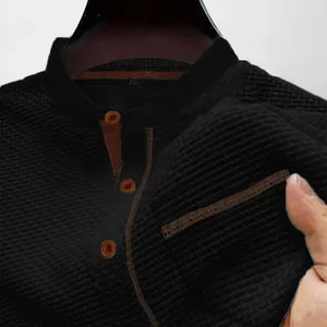 Macro detail of breathable black waffle knit fabric on a men's short sleeve Henley shirt