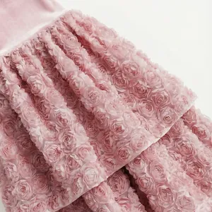 Dettaglio dell'intricato pizzo floreale a rosette 3D rosa su un abito femminile in stile francese