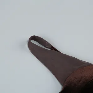 Primer plano de un sexy vestido de noche marrón con tirantes de malla y terciopelo.