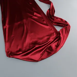 Detalle de la suave tela de satén burdeos en un elegante vestido de noche ajustado