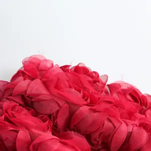 Primer plano detallado de la tela de malla floral 3D roja en un elegante vestido de cóctel mujer