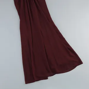 Primer plano del dobladillo de un elegante vestido de noche de gasa color burdeos