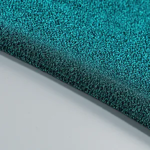 Vue macro d'un tissu lurex bleu sarcelle avec une texture métallique scintillante