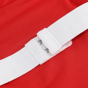 Detalle de la correa elástica blanca con cierre de gancho metálico en un vestido rojo