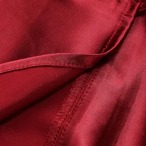 Primer plano de la textura de la tela de raso rojo y los detalles de las costuras de un vestido