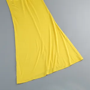 Vista macro detallata del elegante dobladillo y la textura de la tela del vestido largo amarillo