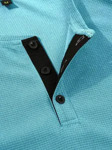 Detail shot of men's light blue waffle knit Henley shirt with black button placket