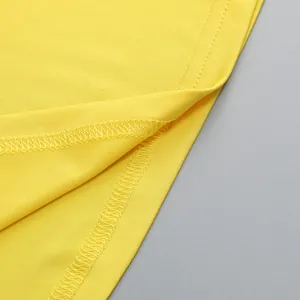 Primer plano del tejido amarillo de un vestido que muestra costuras de alta calidad y detalle