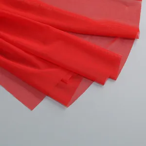 Primer plano de la textura de tela de malla roja vibrante para vestidos de verano