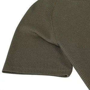 Close-up of olive green waffle knit texture and durable raglan sleeve stitching