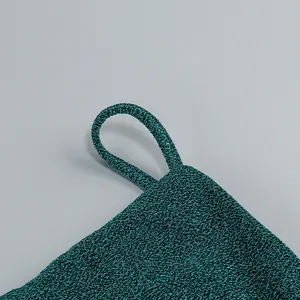 Détail de la bretelle d'une robe vert émeraude en maille texturée scintillante chic.