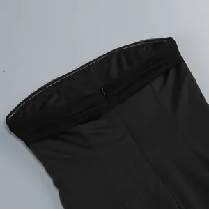 Vista detallada de la cremallera trasera y la tela drapeada de un vestido negro