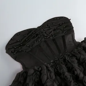 Vista detallada de vestido corto negro con paneles de malla y volantes florales 3D