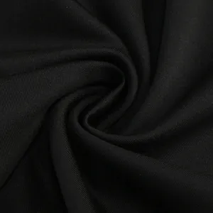 Detalle macro de la tela negra elástica del vestido con textura suave y patrón de tejido