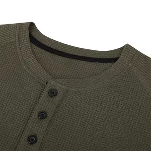 Macro view of men's olive green waffle knit Henley shirt neckline with buttons