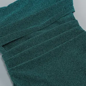 Détail rapproché de la texture du tissu métallique froissé sur une robe vert émeraude