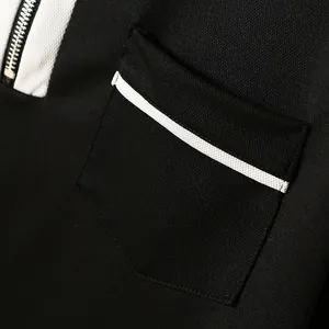 Dettaglio macro di una polo da uomo con taschino sul petto, bordo bianco e colletto a zip.