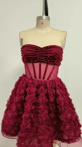 Vista detallada del vestido de fiesta burdeos con falda de flores 3D y cintura de corsé.