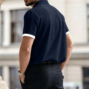 Back view of men's navy blue polo shirt with textured waffle knit and white sleeve trim.