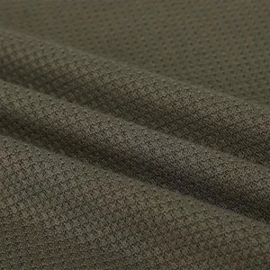 Detailed macro view of olive green waffle knit fabric for men's casual Henley polo shirt