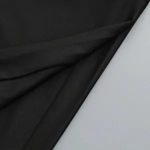 Vista detallada de la fina textura y la caída suave de la tela de punto de color negro