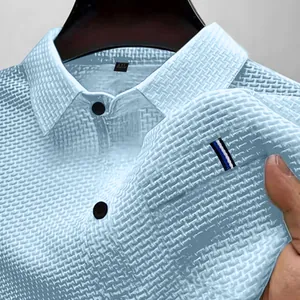 Primo piano di una polo in seta di ghiaccio celeste con trama a nido d'ape e dettagli