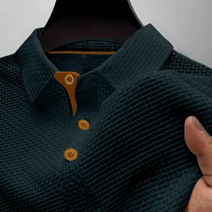 Primer plano de polo de hombre azul marino texturizado de alta calidad con botones naranja