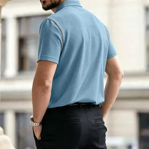 Detail view of men's blue breathable waffle knit polo shirt showing back and fabric texture