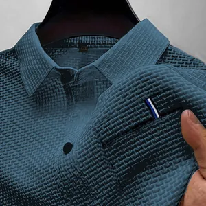 Primo piano della tasca di una polo testurizzata color foglia di tè con dettaglio a righe