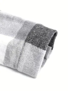 Detailed macro view of a grey and white plaid shirt cuff featuring thick fabric texture.