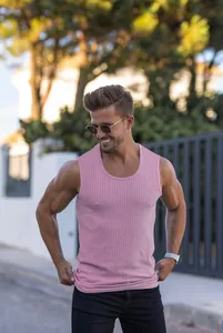 Close-up view of a pink ribbed slim-fit men's fitness tank top in an outdoor setting