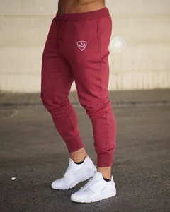 Detailed view of men's slim fit maroon joggers paired with stylish white chunky sneakers.