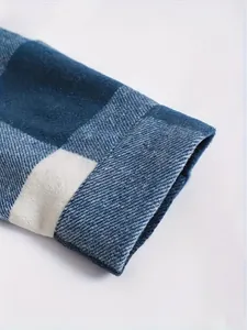 Close-up detail of a blue plaid shirt sleeve cuff showing the thick flannel fabric texture.