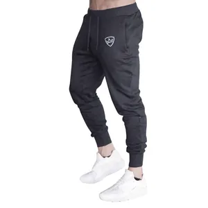 Side view of dark grey men's slim fit joggers featuring drawstring waist and crown logo detail