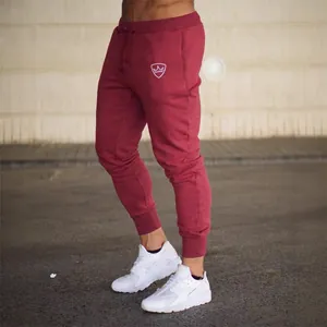 Men's slim fit burgundy jogger pants with drawstring waist and embroidered crown logo