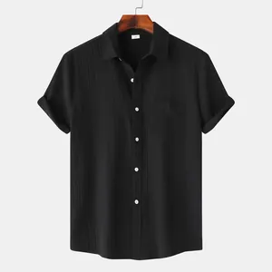 Detalle de camisa negra de manga corta con textura arrugada y un bolsillo en el pecho