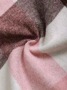 Detailed macro shot of soft pink and white plaid fabric texture for men's winter shirt.