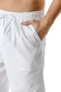 Close-up of white linen pants pocket showing fabric texture and drawstring waist.