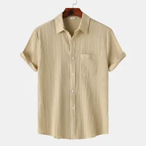 Detalle de camisa beige de manga corta para hombre con textura arrugada vertical y bolsillo