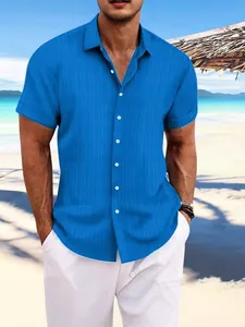 Bright blue men's cotton linen short sleeve shirt with vertical striped jacquard on a beach.