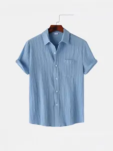 Camisa de hombre de manga corta azul claro con textura arrugada y bolsillo frontal