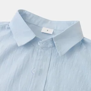 Detailed close-up view of a light blue linen shirt collar with a white M size tag
